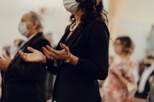 Masked people praying in church