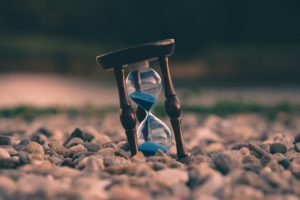 hourglass on rocky ground